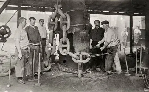 Fotografía histórica de herreros forjando eslabones de cadena de ancla en la fragua de Netherton en 1910