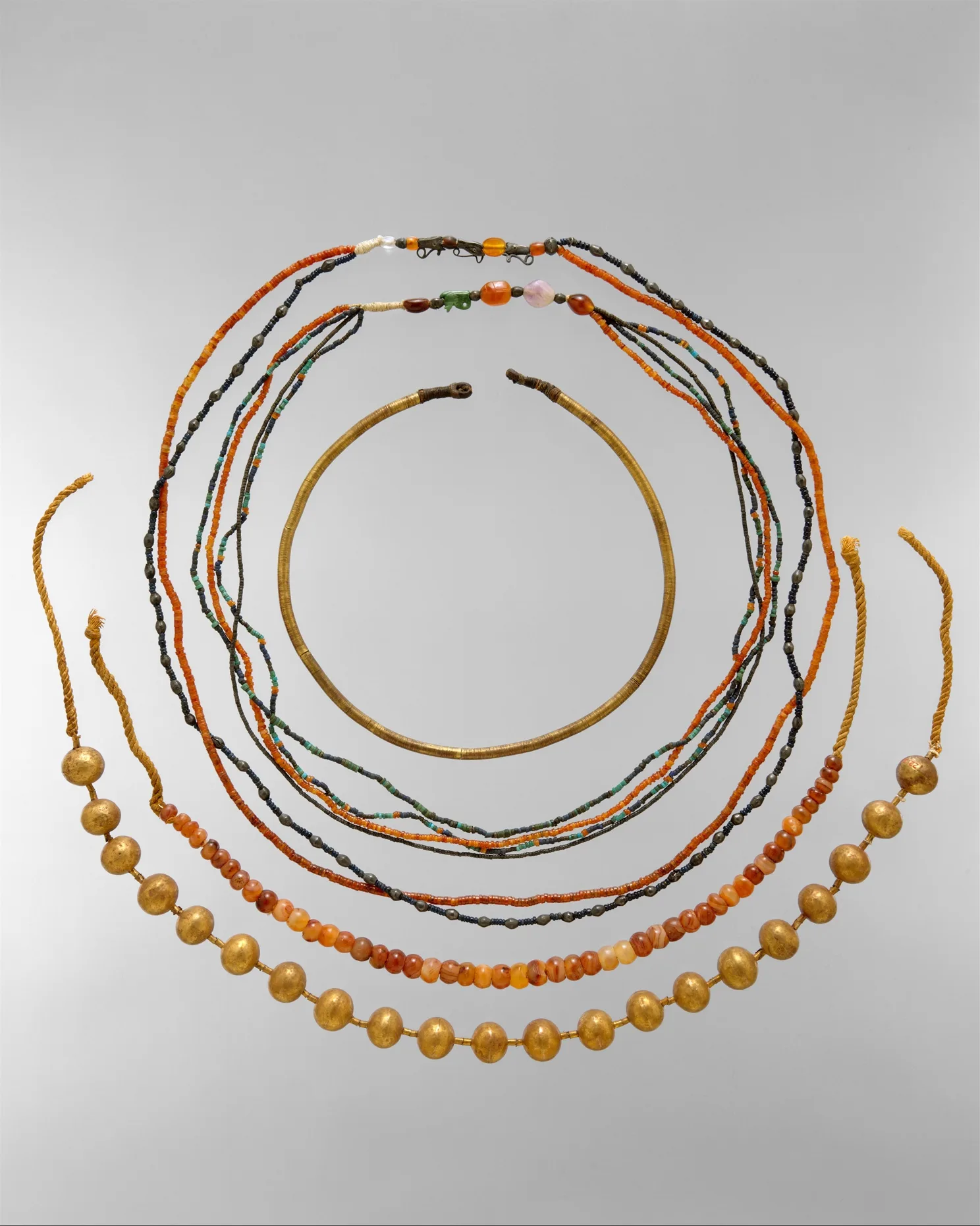 Joya del antiguo Egipto con piedras y oro sobre base de cuero y lino