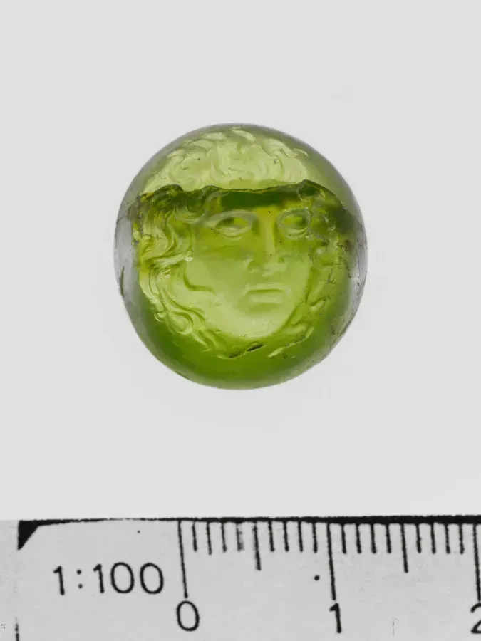 Intaglio romano antiguo de peridoto con un retrato grabado, piedra verde amarillenta