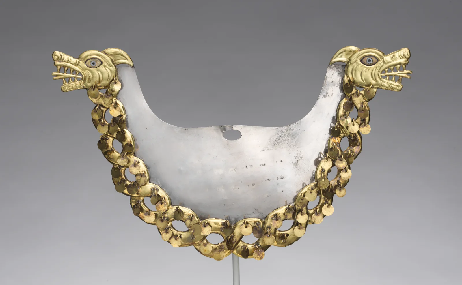 Ornamento nasal de oro y plata con criaturas entrelazadas, cultura moche, años 500 a 800